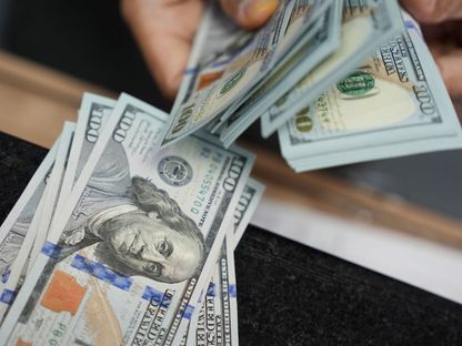 شخص يعد أوراقاً نقدية من الدولار الأميركي في مكتب صرف للعملات - المصدر: بلومبرغ