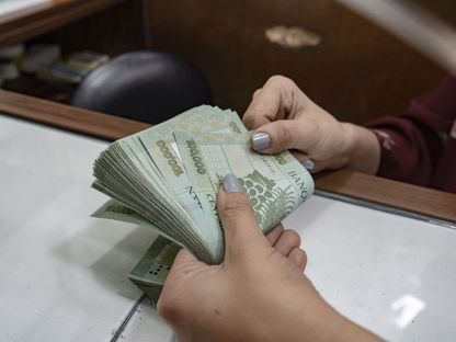 موظفة تعد أوراقاً نقدية من فئة 100 ألف ليرة لبنانية - المصدر: بلومبرغ