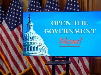 شاشة عرض أثناء مؤتمر صحفي في مبنى الكابيتول الأميركي بالعاصمة واشنطن، بتاريخ 3 نوفمبر 2025، تُظهر عبارة: \"افتحوا الحكومة الآن!\" - بلومبرغ