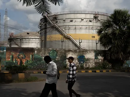 مشاة يسيرون أمام صهاريج تخزين في مصفاة نفط بمدينة مومباي، الهند - بلومبرغ