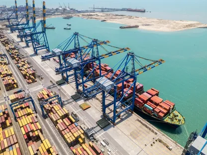 رافعات عملاقة على رصيف الشحن أثناء تحميل سفينة حاويات في ميناء موندرا التابع لشركة \"أداني\" للموانئ والمنطقة الاقتصادية الخاصة المحدودة في موندرا بولاية غوجارات، الهند - بلومبرغ