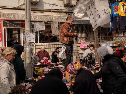 بائع يعرض بضاعته من الملابس واقفاً في إسطنبول، تركيا  - المصدر: بلومبرغ