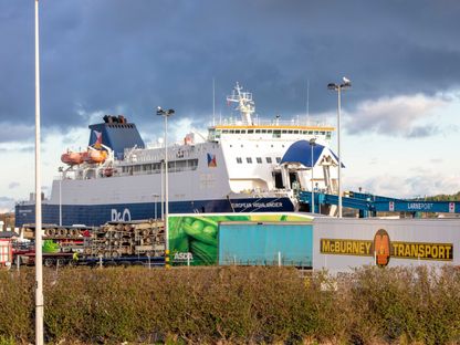 شاحنات نقل بالقرب من عبّارة هايلاندر الأوروبية في ميناء لارن في لارن بأيرلندا الشمالية. - المصدر: بلومبرغ