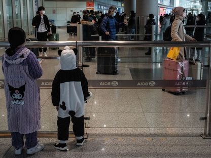 طفلان ينتظران أحد أقاربهما في صالة الوصول في مطار العاصمة بكين - المصدر: بلومبرغ