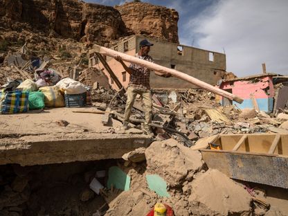 مواطن فوق أنقاض منزل منهار بسبب الزلزال الذي ضرب في سبتمبر 2023 نواحي مدينة مراكش، وسط المغرب - المصدر: بلومبرغ