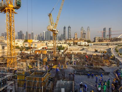 عمال في موقع للإنشاءات السكنية على امتداد \"قناة دبي المائية\"، الإمارات - المصدر: بلومبرغ