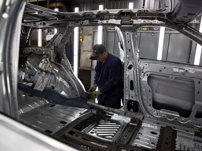 موظف يتفقد إطار سيارة في مصنع شيكاغو للتجميع في شركة فورد بالولايات المتحدة - بلومبرغ