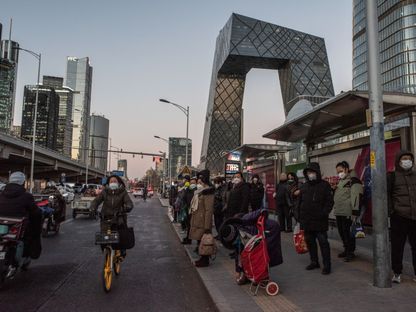 المارة يسيرون في الطرق وهم يرتدون أقنعة طبية، بكين، الصين - المصدر: بلومبرغ