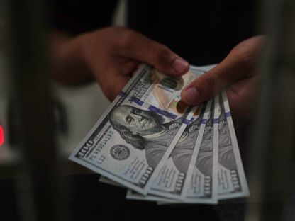 عامل يحمل أوراقًا من فئة الدولار الأميركي في مكتب صرافة بجاكرتا  إندونيسيا  يوم الأربعاء 2 مارس 2022. - المصدر: بلومبرغ