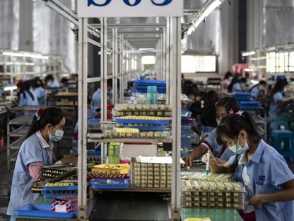 عمال يعملون على خط تجميع الترانزستورات في مصنع \"شنغهاي إلكترونيك\" بمقاطعة يونان، الصين - المصدر: بلومبرغ
