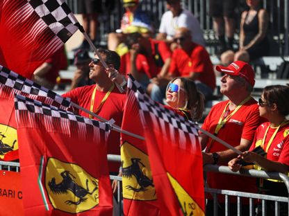 مشجعو \"فيراري\" يلوحون بالأعلام دعماً لفريقهم قبيل انطلاق مسابقات \"الجائزة الكبرى إف 1\" اليوم، في \"أوتودرومو نازيونال مونزا\"، في إيطاليا  - المصدر: بلومبرغ