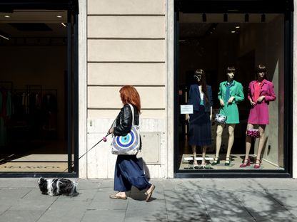 سيدة تمر أمام متجر لبيع الملابس في وسط مدينة روما بإيطاليا - المصدر: بلومبرغ