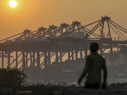 مشهد غروب الشمس فوق الرافعات الجسرية في ميناء جواهر لال نهرو، الذي تديره شركة \"جواهر لال نهرو بورت تراست\" في نافي مومباي، ماهاراشترا، الهند - المصدر: بلومبرغ