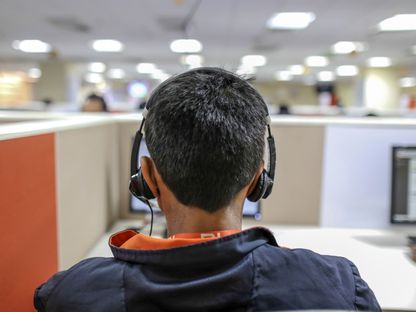 يتلقى موظف مكالمة في أحد مراكز الاتصال التي تخدم شركة \"شاومي\" في بنغالور، الهند. - المصدر: بلومبرغ