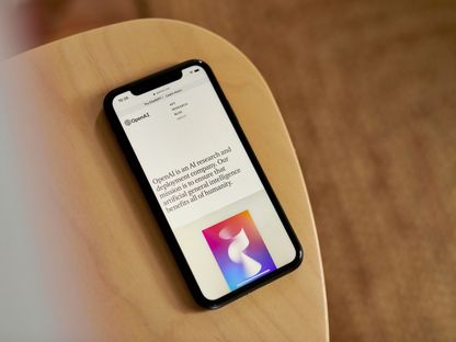صورة لهاتف ذكي يظهر على شاشته تعريف بشركة \"أوبن إيه آي\" لتقنيات الذكاء الصناعي - المصدر: بلومبرغ