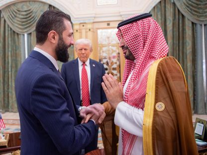 الرئيس السوري أحمد الشرع يصافح ولي العهد السعودي الأمير محمد بن سلمان بحضور الرئيس الأميركي دوناد ترمب قبل اجتماع في الرياض، 14 مايو 2025 - وكالة الأنباء السعودية