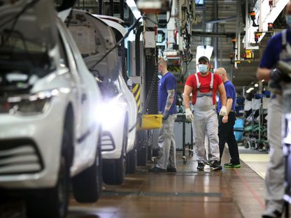 موظفون يراقبون خط إنتاج سيارات في مصنع فولكس واجن في فولفسبورغ بألمانيا - المصدر: بلومبرغ