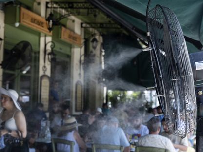 المراوح ورشاشات الرذاذ تخفف الحر على زبائن المطاعم خلال الطقس الحار - المصدر: بلومبرغ