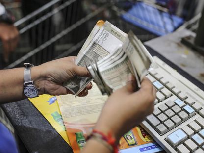 موظف في مكتب لصرف العملات يعد أوارقاً نقدية من فئة 500 روبية هندية - المصدر: بلومبرغ
