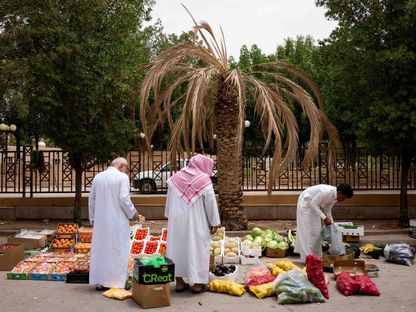 رجلان يقفان أمام بسطة من الخضار والفواكه، فيما يجهّز بائع طلبية أحدهما في أحد الأحياء بمدينة الرياض. المملكة العربية السعودية - المصدر: بلومبرغ