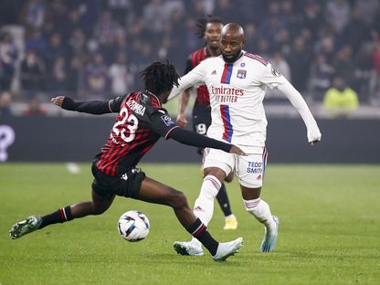 موسى ديمبلي لاعب \"أولمبيك ليون\" يمر بالكرة من جوردون لوتومبا لاعب \"نيس\" في مباراة جمعت الفريقين - المصدر: غيتي إيمجز