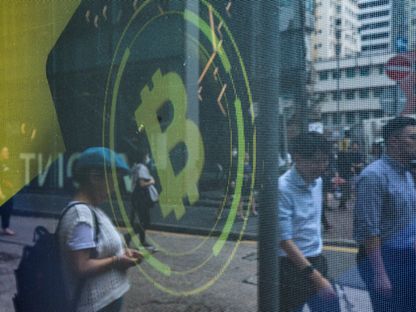 شعار \"بتكوين\" على شاشة في هونغ كونغ، الصين. - المصدر: بلومبرغ