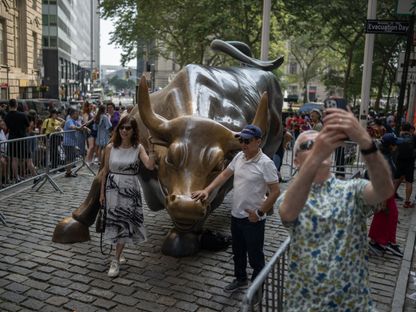 زوار حول تمثال \"الثور الهائج\" (Charging Bull) بالقرب من بورصة نيويورك (NYSE) في نيويورك، الولايات المتحدة، يوم الخميس 29 يونيو 2023. - المصدر: بلومبرغ