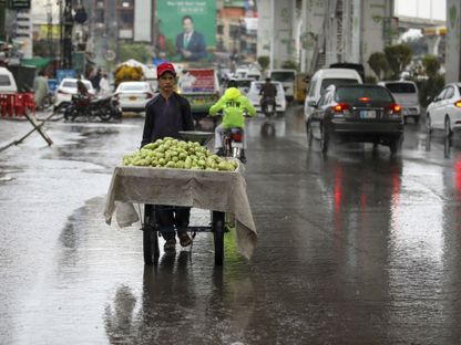 بائع فواكه متجول تغمره الأمطار بروالبندي في باكستان - المصدر: بلومبرغ