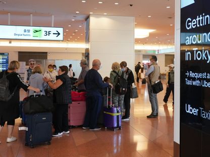 مسافرون يصلون إلى مطار هانيدا في طوكيو، اليابان.  - المصدر: بلومبرغ