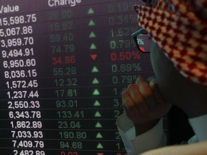 رجل يطالع لوحة إلكترونية تعرض أسعار أسهم داخل سوق الأسهم السعودية (صورة أرشيفية) - المصدر: بلومبرغ
