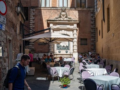 زبائن يجلسون في شرفات أحد المطاعم بمنطقة \"سيينا\" في إيطاليا، بتاريخ 11 سبتمبر 2023 - المصدر: بلومبرغ