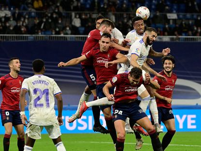 لاعبون يتقاتلون من أجل الكرة خلال مباراة كرة قدم بالدوري الأسباني بين \"ريال مدريد\" و\"أوساسونا\" في مدريد في 27 أكتوبر 2021 - المصدر: غيتي إيمجز