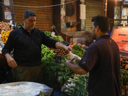 بائع يخدم أحد العملاء في كشك للمنتجات الطازجة في سوق ليلي في الإسكندرية، مصر، يوم الثلاثاء 6 ديسمبر 2022. - المصدر: بلومبرغ