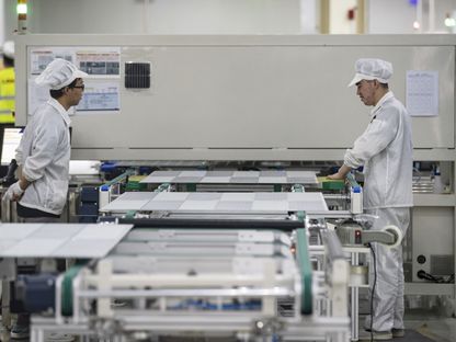 عمال يصنعون ألواحاً كهروضوئية في الصين - المصدر: بلومبرغ