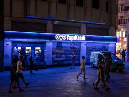 أشخاص يمرون أمام أحد فروع بنك \" يابي كريدي\" في إسطنبول، تركيا - المصدر: بلومبرغ