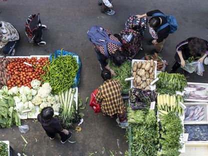 عملاء يتسوقون الخضروات في سوق بمنطقة قرية جيوشيا في شنتشن، الصين - المصدر: بلومبرغ