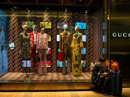 سيدة تجلس أمام وجهة متجر \"غوتشي\" للسلع الفاخرة في منطقة تسيم شا تسوي بهونغ كونغ، الصين (صورة أرشيفية) - المصدر: بلومبرغ