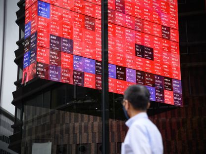 شخص ينظر إلى أسعار الأسهم على شاشة \"المكعب الدوار\" في ردهة مبنى كابوتو وان، بجوار بورصة طوكيو. طوكيو، اليابان، في 7 يونيو 2022. - المصدر: بلومبرغ