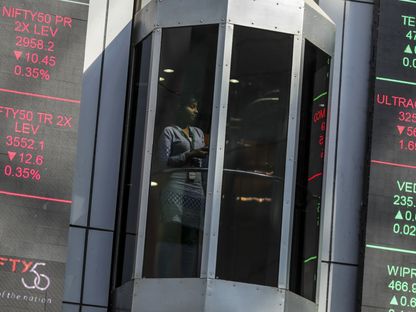 مصعد يتحرك بجوار اللوحات الإلكترونية التي تعرض أرقام الأسهم في مبنى البورصة الوطنية الهندية (NSE) في مومباي، الهند، يوم الجمعة، 16 ديسمبر 2016. - المصدر: بلومبرغ