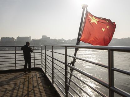 العلم الوطني الصيني يرفرف على سطح العبارة التي تعبر نهر اليانغتسى في ووهان، هوبى، الصين - المصدر: بلومبرغ