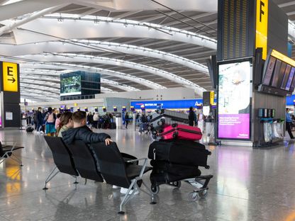 راكبان ينتظران في منطقة استكمال إجراءات السفر بمطار \"هيثرو\" في لندن - المصدر: بلومبرغ