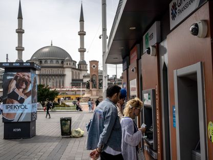 أشخاص يستخدمون جهاز صراف آلي عند أحد المصارف في إسطنبول، تركيا - المصدر: بلومبرغ