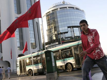 شاب يعبر الشارع وخلفه حافلة نقل عام في مدينة الدار البيضاء، المملكة المغربية - المصدر: بلومبرغ