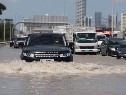 السائقون يحاولون نقل سياراتهم على طول طريق سريع مغمور بالمياه بعد عاصفة مطيرة في دبي، الإمارات العربية المتحدة - المصدر: بلومبرغ