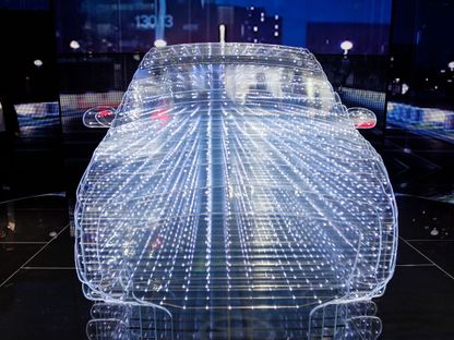 شاشة تظهر تركيب ضوئي على شكل سيارة في معرض جنيف الدولي للسيارات، سويسرا  - المصدر: بلومبرغ