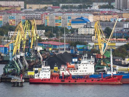 أوناش تنتظر بجوار كومة من الفحم بمحطة حاويات تشغلها شركة \"سيبيريان كول إنرجي\" (Siberian Coal Energy)، المعروفة اختصاراً باسم SUEK، في ميناء \"مورمانيسك\"، روسيا، بتاريخ 14 سبتمبر 2019 - المصدر: بلومبرغ