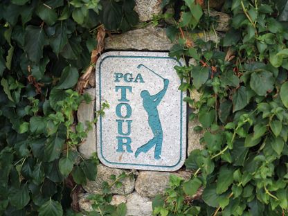 شعار دوري رابطة الغولف للمحترفين منقوش على حجر بين الأشجار - المصدر: بلومبرغ