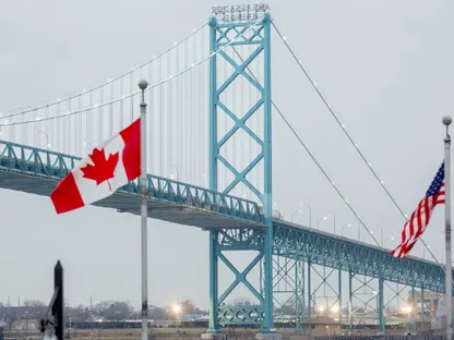 العلمان الكندي والأميركي بالقرب من جسر إمباسادور على الحدود بين كندا والولايات المتحدة في مدينة وندسور، أونتاريو، كندا - بلومبرغ