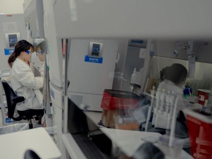 عالمتان تعملان على تطوير أدوية ولقاحات في مختبر معملي - المصدر: بلومبرغ