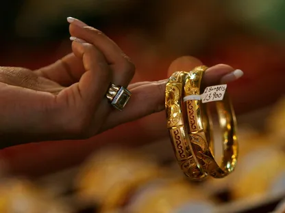 امرأة تفحص أساور ذهبية في محل مجوهرات بمدينة مومباي في 8 أكتوبر 2009 - رويترز